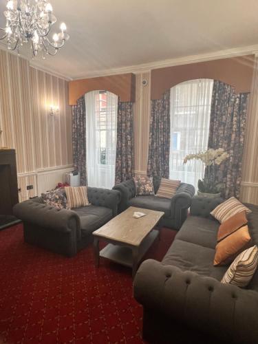 a living room with a couch and a table at Hotel Cavendish - Bloomsbury in London