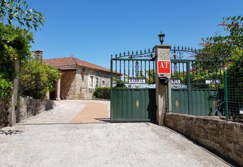 um portão com um sinal de ak em frente a uma casa em Apartamentos Barral Meu Lar em Valga