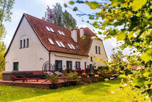 a large white house with a red roof at Stara Szkoła Browina in Browina