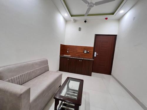 a living room with a couch and a wooden door at HR Grand Hotel in New Delhi