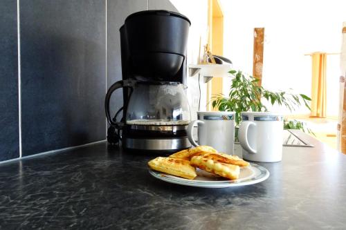 a plate of bread on a counter with a coffee maker at Apartment Mountain View in Fliess
