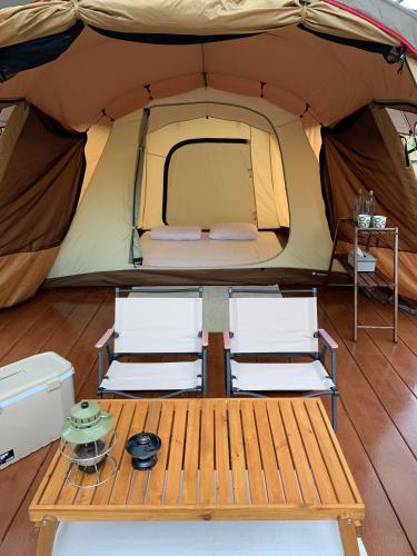 a tent with two chairs and a table in it at Moosiyard Hometel Khaoyai in Mu Si