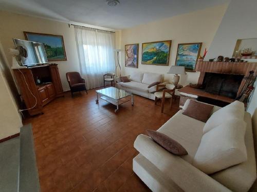 a living room with a couch and a table at Villa Pilar in Toscana con piscina ultrapanoramica in Montevettolini