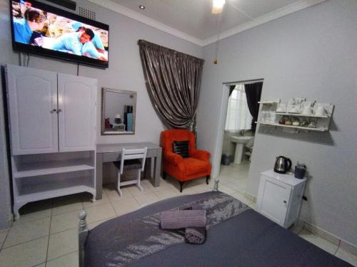 a bedroom with a bed and a tv on the wall at 21on2nd Avenue in Tzaneen