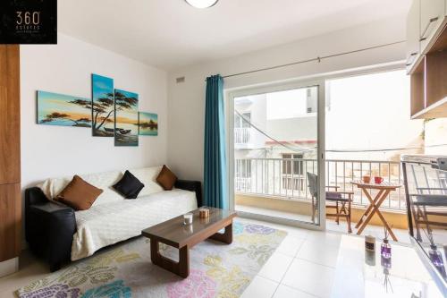 una sala de estar con un sofá y una mesa en Beautiful, TOP NOTCH 1 BR APT just off the coast by 360 Estates, en St Paul's Bay