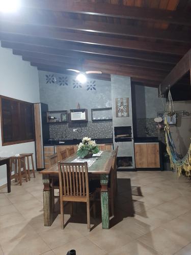 una sala da pranzo con tavolo e sedie in legno di Suítes Canola a Ubatuba