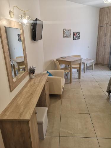 a living room with a table and a mirror at Porfyris Studios and Apartments in Karpathos Town