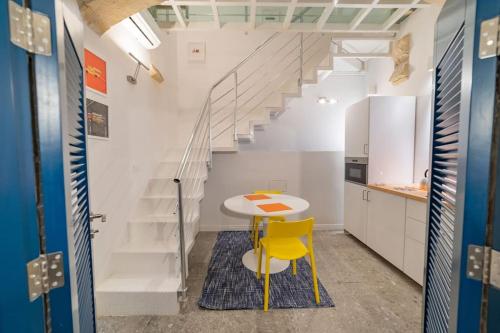 uma cozinha com uma mesa e uma cadeira amarela em DZC- Dazzle Den em Valletta