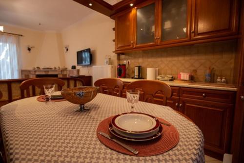 a kitchen with a table with plates and glasses on it at My Nafpaktos Resort in Nafpaktos