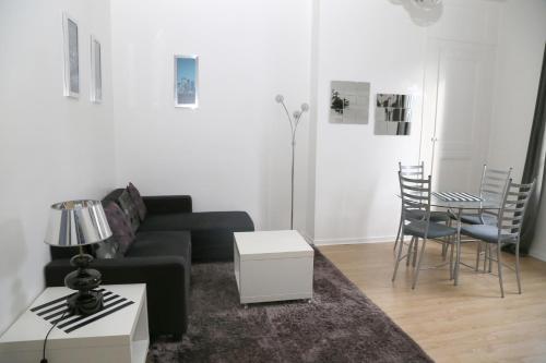 sala de estar con sofá negro y mesa en Appartement 3 pièces, en Honfleur