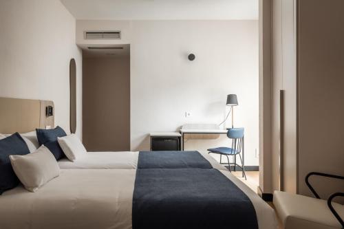 Habitación de hotel con cama y escritorio en Hotel Don Jaime 54 en Zaragoza