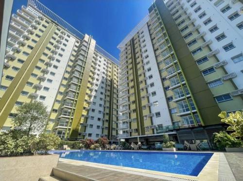 a view of three apartment buildings with a swimming pool at Mesaverte Deluxe Studio with Balcony in Cagayan de Oro
