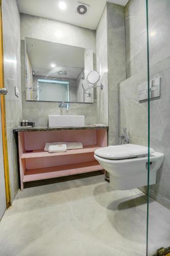 a bathroom with a sink and a toilet and a mirror at The Stories Hotel in Ludhiana