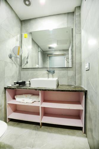 a bathroom with a sink and a large mirror at The Stories Hotel in Ludhiana