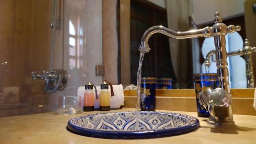 a bathroom sink with a faucet and a blue and white sink at Riad Nafis in Marrakesh
