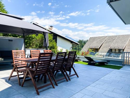 a wooden table and chairs on a patio at Lakeview Villa Bled in Bled