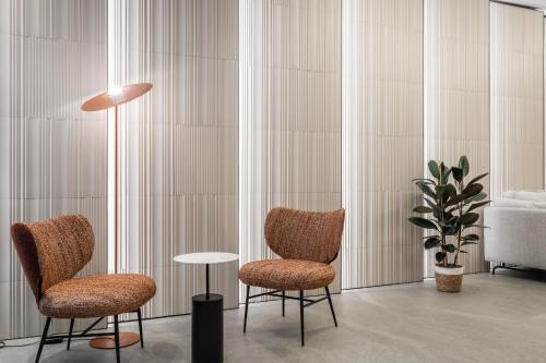 two chairs and a table in a room at Hotel Don Jaime 54 in Zaragoza