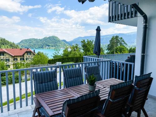 a table and chairs on a balcony with a view of the water at Lakeview Villa Bled in Bled