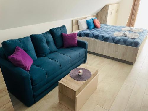 a living room with a blue couch and a bed at Vuk apartment - Milmari Resort & Spa in Kopaonik