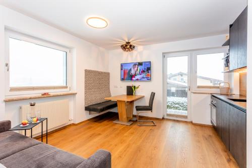 ein Wohnzimmer mit einem Sofa und einem Tisch in der Unterkunft Apartmenthaus Maximilian in Neukirchen am Großvenediger
