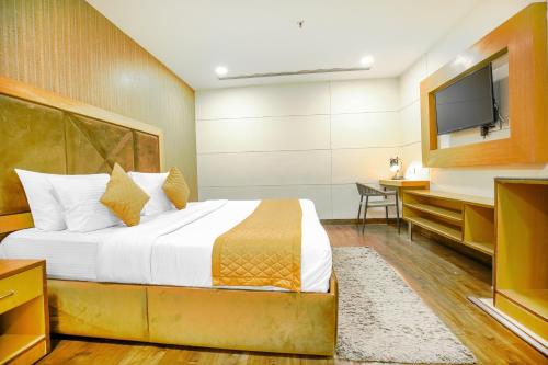 a hotel room with a bed and a flat screen tv at The Stories Hotel in Ludhiana
