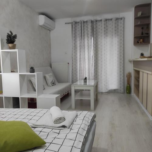 een witte kamer met een bed en een bank bij Apartman Jevrejska Banja Luka in Banja Luka