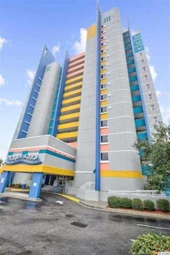 a building with two tall buildings in a parking lot at Beach-side Condo w Pools in Myrtle Beach