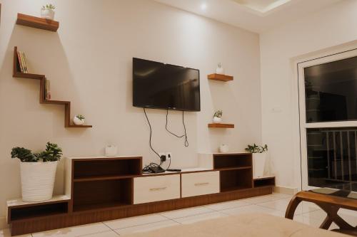 a living room with a flat screen tv on a wall at Sprise Munnar Resort and Spa in Munnar