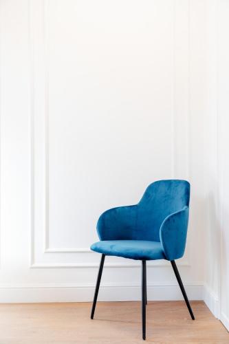 a blue chair sitting in a room at Warsaw Story - LoftAffair Collection in Warsaw