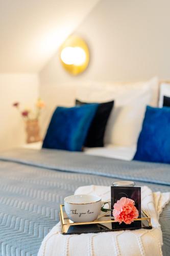 a tray with a cup and a bowl on a bed at Warsaw Story - LoftAffair Collection in Warsaw