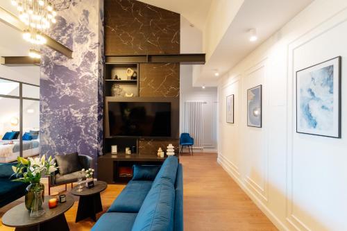 a living room with a blue couch and a tv at Warsaw Story - LoftAffair Collection in Warsaw