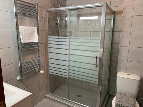 a bathroom with a shower with a toilet and a sink at Rivendell Apartments Flora Complex in Borovets