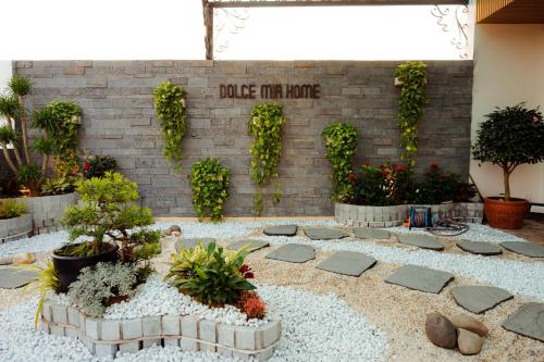 a garden with potted plants and a brick wall at Dolce Mia Home Ninh Bình in Ninh Binh