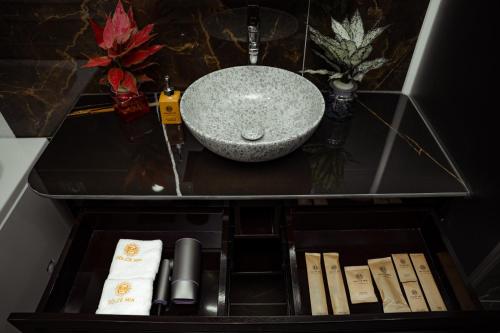 a bathroom with a sink and a granite counter top at Dolce Mia Home Ninh Bình in Ninh Binh