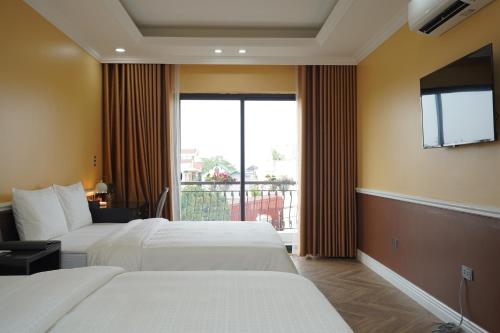 um quarto de hotel com duas camas e uma grande janela em Dolce Mia Home Ninh Bình em Ninh Binh
