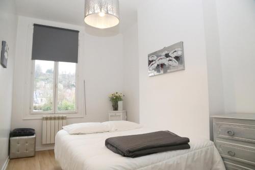 オンフルールにあるアパルトマン 3 ピエースのベッドと窓のある白い寝室