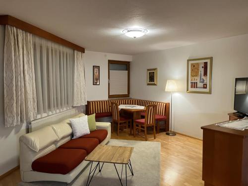 - un salon avec un canapé et une table dans l'établissement Aparthaus Camping Stubai, à Neustift im Stubaital