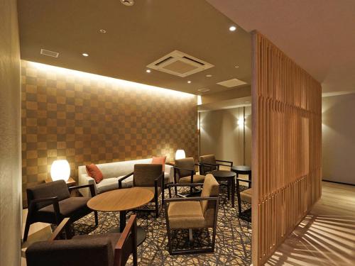 a waiting room with tables and chairs in a building at CHISUN PREMIUM Kyoto Kujo in Kyoto
