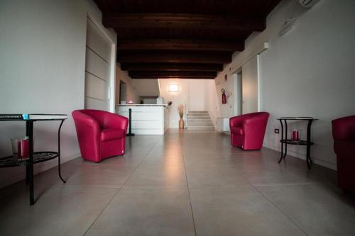 Habitación con 2 sillas rojas y mesa. en Agriturismo Il Colle Dei Lecci, en Ancona