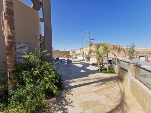 a patio outside of a building with chairs and plants at Villa Tzukim Mitzpe Ramon in Mitzpe Ramon