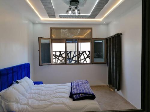 um quarto com uma cama e uma janela em Appartement lux dakhla em Dakhla