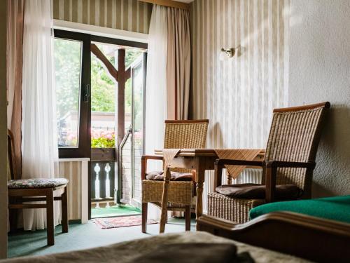 Zimmer mit einem Tisch, Stühlen und einem Fenster in der Unterkunft Haus Sabine - Familienzimmer 1 in Braunlage