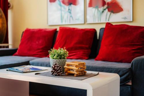 a living room with red pillows and a coffee table at Chalet Paulsbergwiese in Braunlage