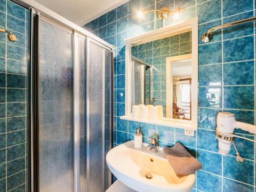 ブラウンラーゲにあるweißer Hirsch im Haus Sabineの青いタイル張りのバスルーム(シンク、シャワー付)