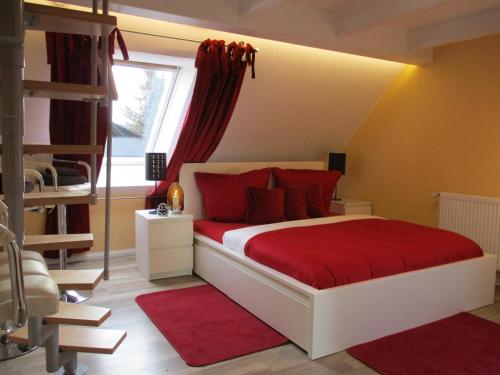 a bedroom with a bed with red pillows and a window at Chalet Platzhirsch in Braunlage