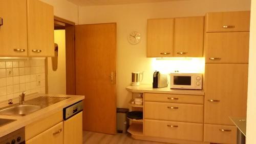 eine kleine Küche mit einer Spüle und einer Mikrowelle in der Unterkunft Bergfried 1 in Braunlage