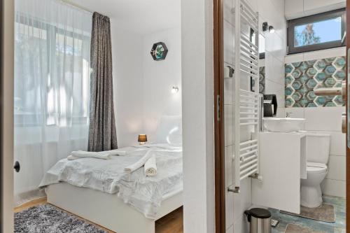 a white bathroom with a bed and a sink at Pensiunea Podul Simonului in Bran