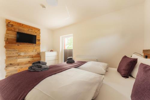 a bedroom with a bed and a tv on a wall at Reitstieg in Braunlage