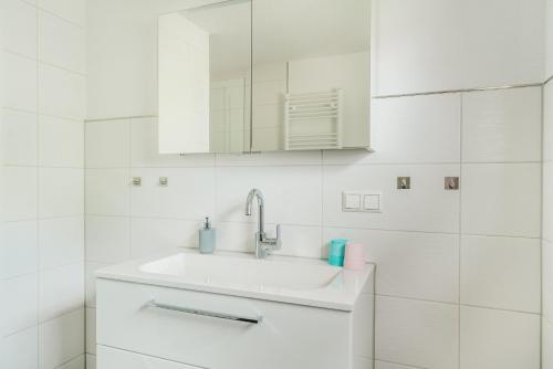 a white bathroom with a sink and a mirror at Reitstieg in Braunlage