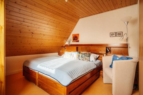 een slaapkamer met een groot bed in een houten muur bij JermersteinSonne in Braunlage